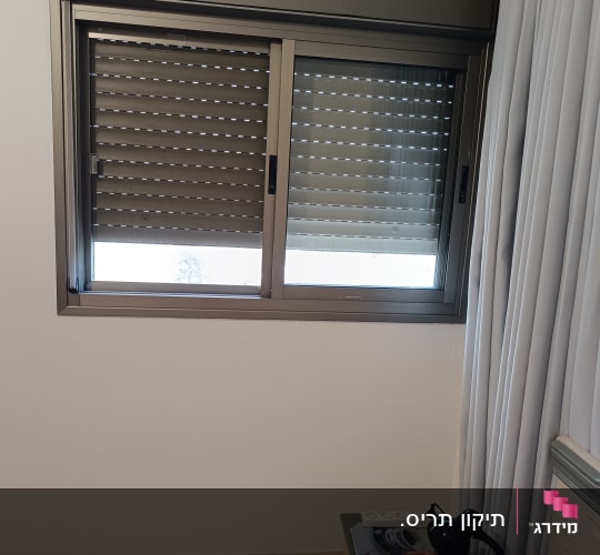 חלון עם תריסים סגורים בחדר שינה